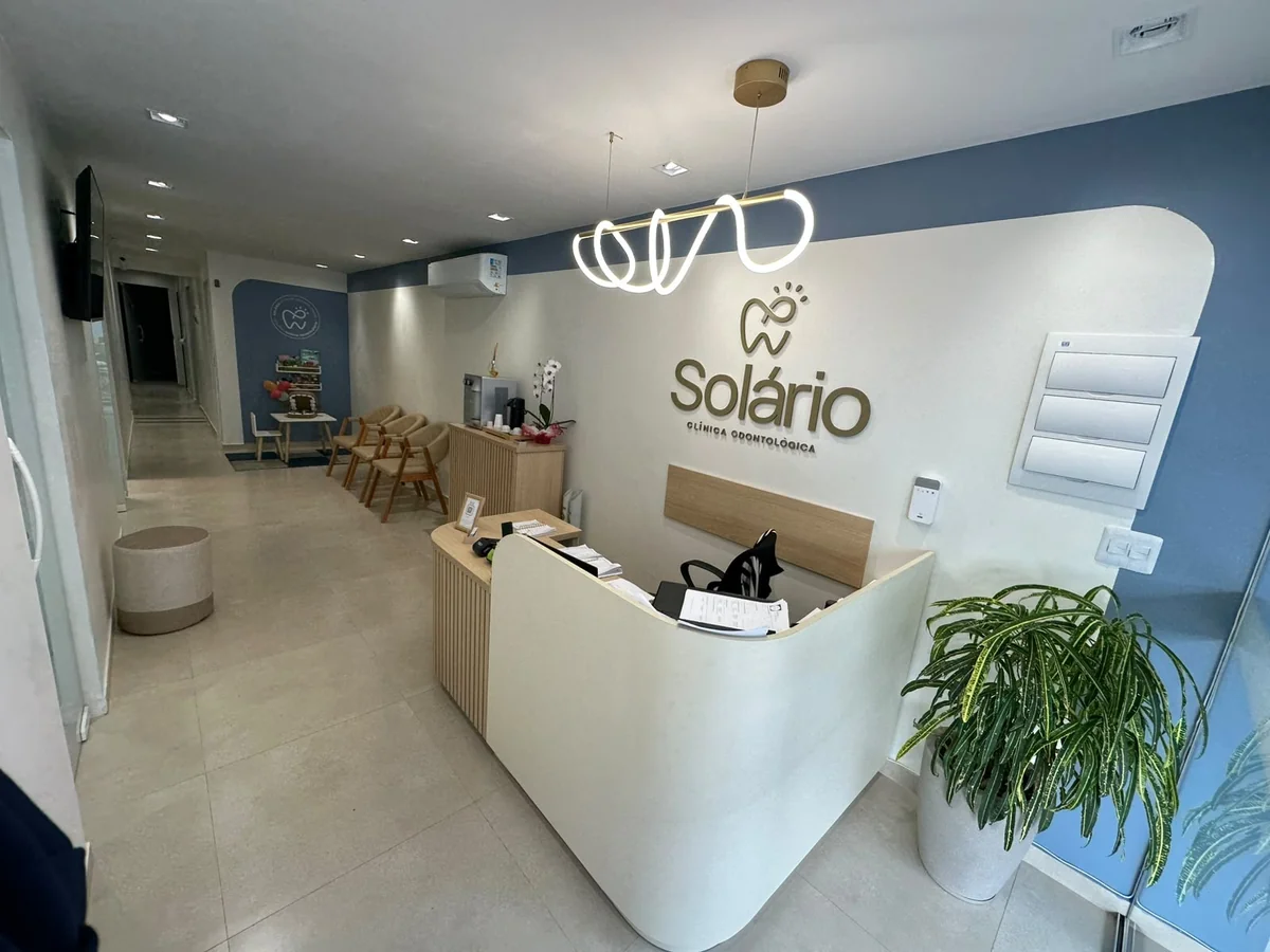 Recepção da Solário em Papucaia, com balcão curvo, logotipo na parede e espaço de espera.